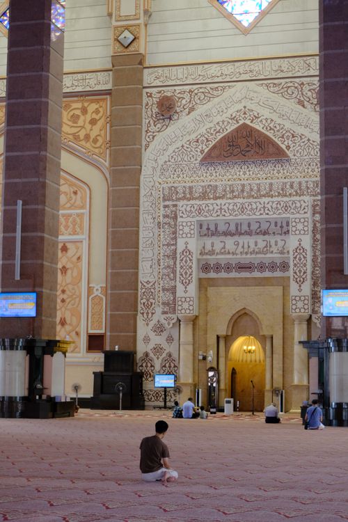Free Wide view of a mosque's intricate interior design with people praying. Stock Photo