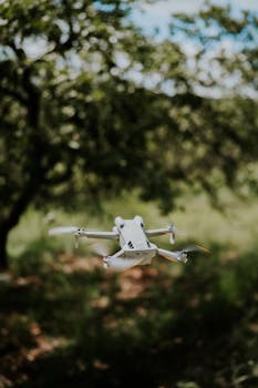 Drone flying amidst a lush forest showcasing technology in nature.