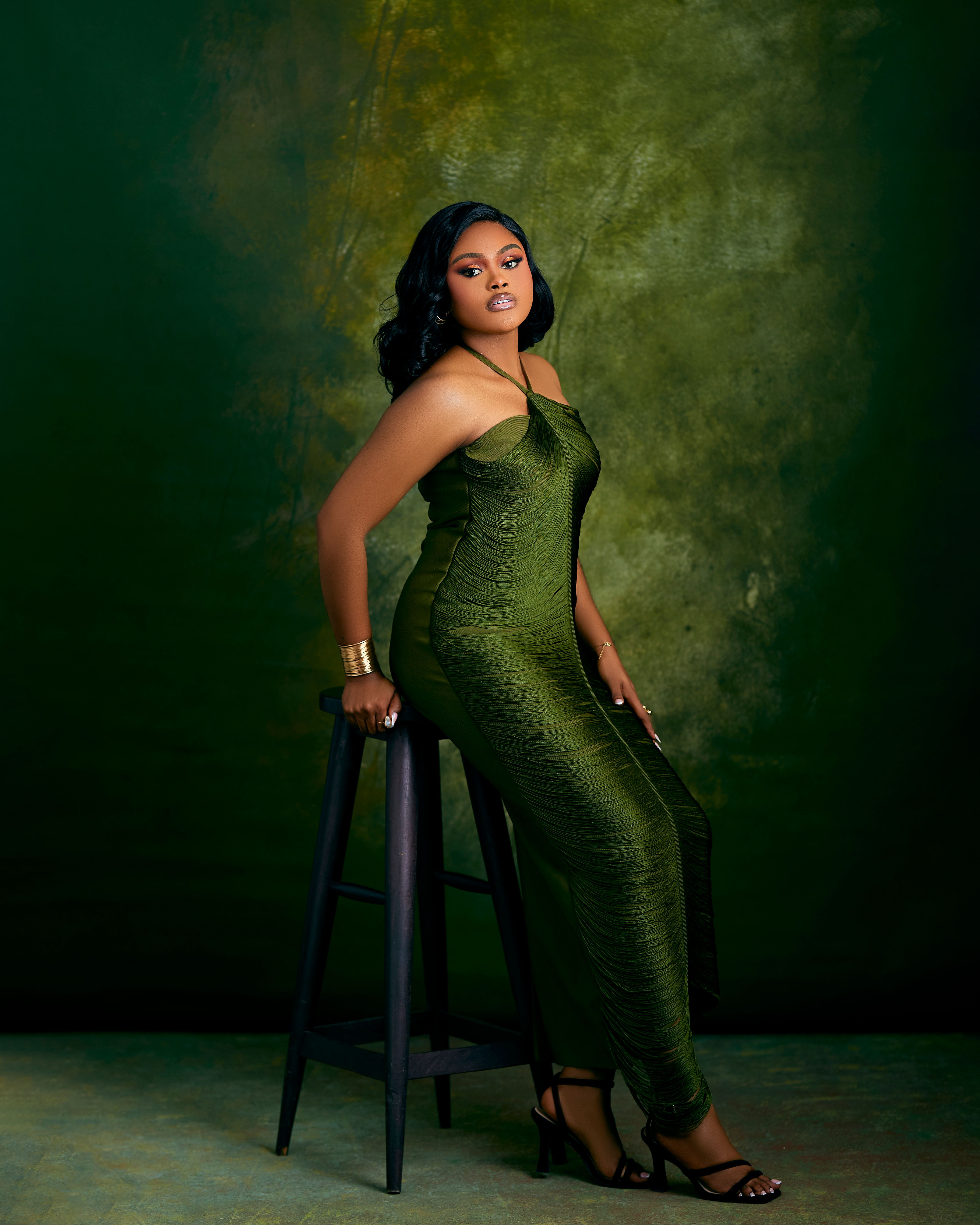 Elegant Woman in Green Dress Against Textured Background  Free Stock Photo