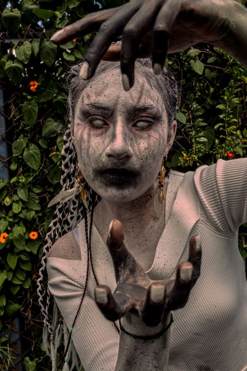Free A woman with eerie Halloween makeup poses outdoors, creating a spooky atmosphere. Stock Photo