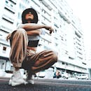 一位时尚女性身着街头服饰，在城市背景下摆出姿势