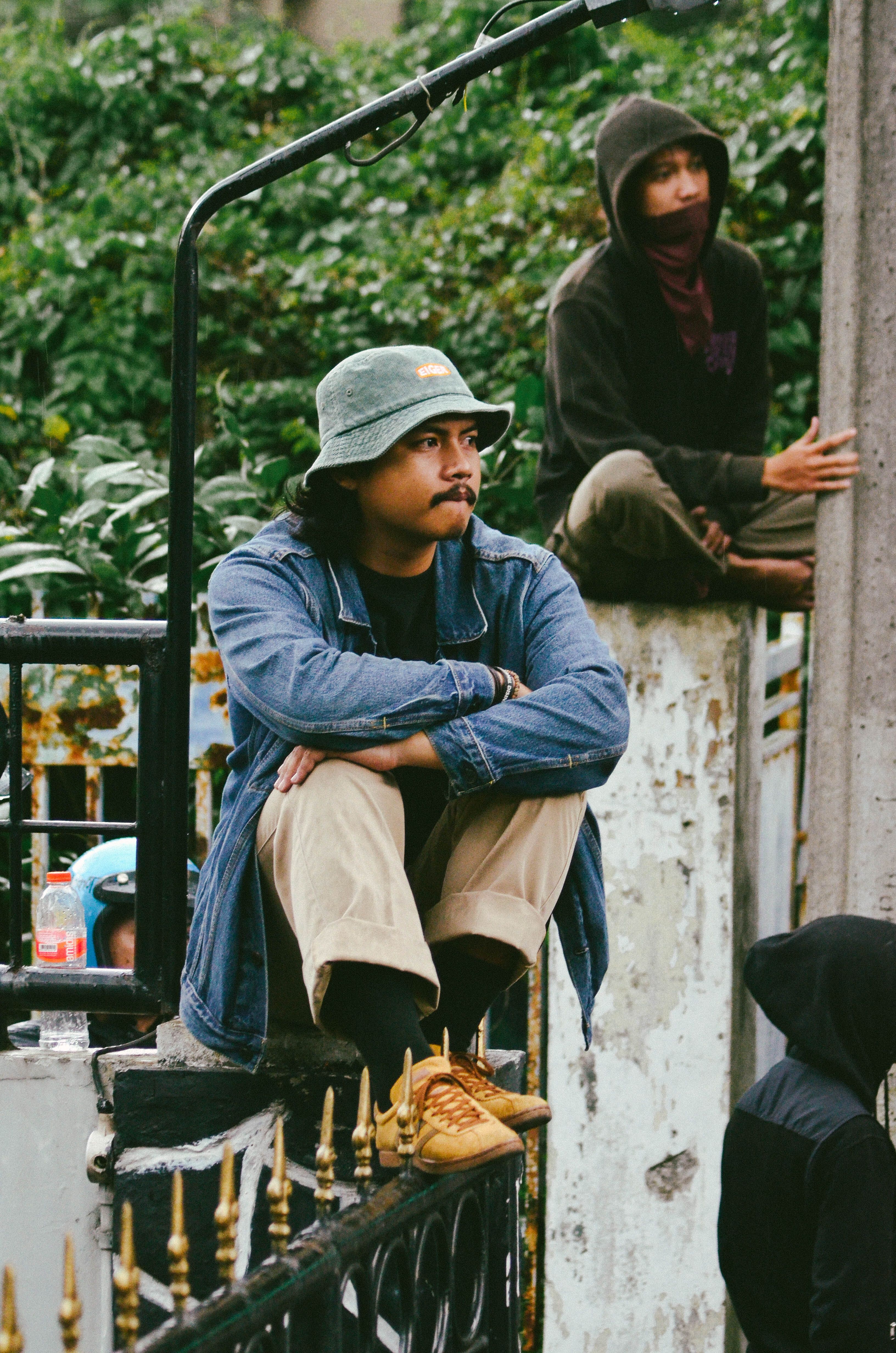 Young individuals gather casually in a Bandung street scene, embracing urban culture and friendship.