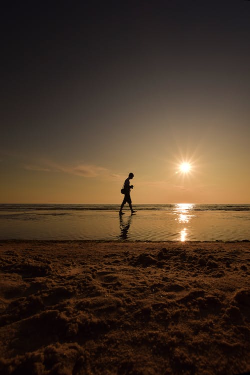 Foto profissional grátis de céu, homem andando, litoral