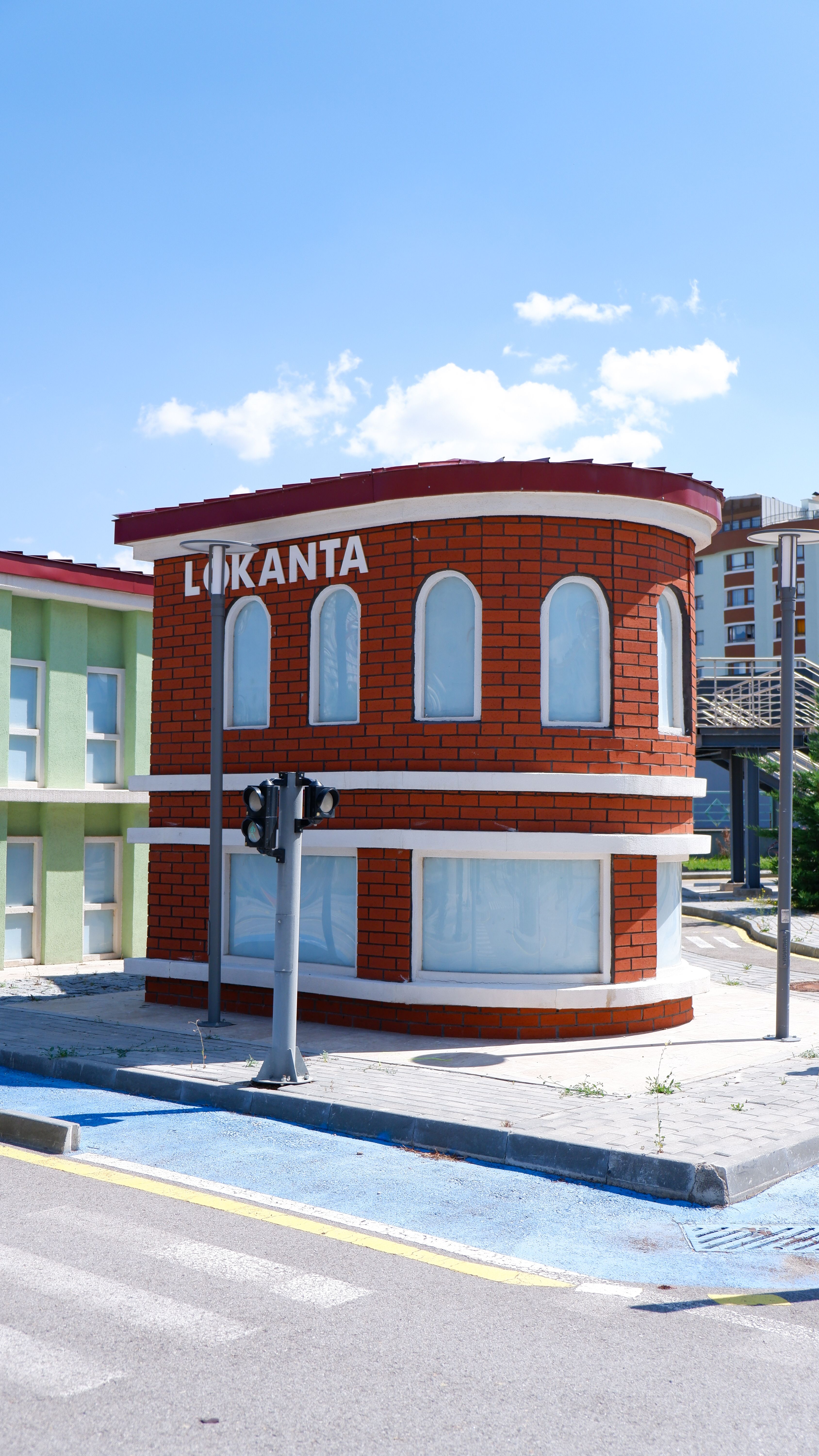 A sunny day in Ankara showcasing a street view with a Lokanta building and modern surroundings.