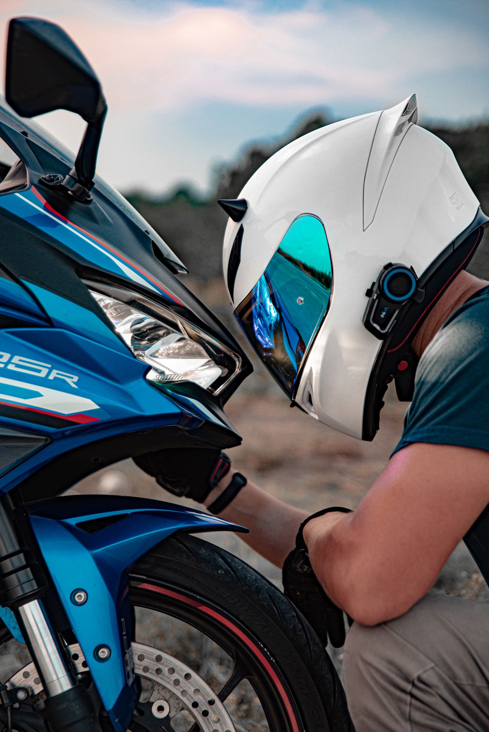 Motard casqué inspectant sa moto sportive avant de partir