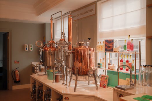 A beautifully lit distillery room showcasing elegant copper brewing equipment.