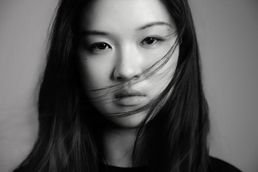 Artistic black and white portrait of a young woman with flowing hair.