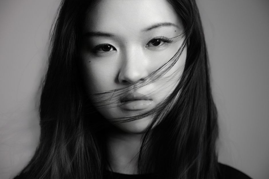 Artistic black and white portrait of a young woman with flowing hair.