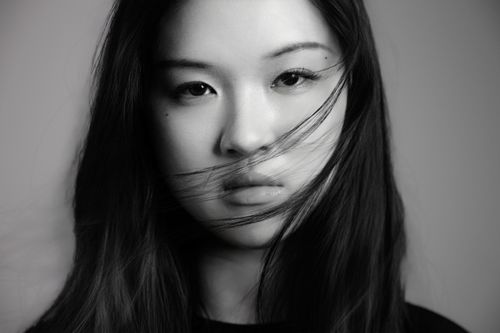 Free Artistic black and white portrait of a young woman with flowing hair. Stock Photo
