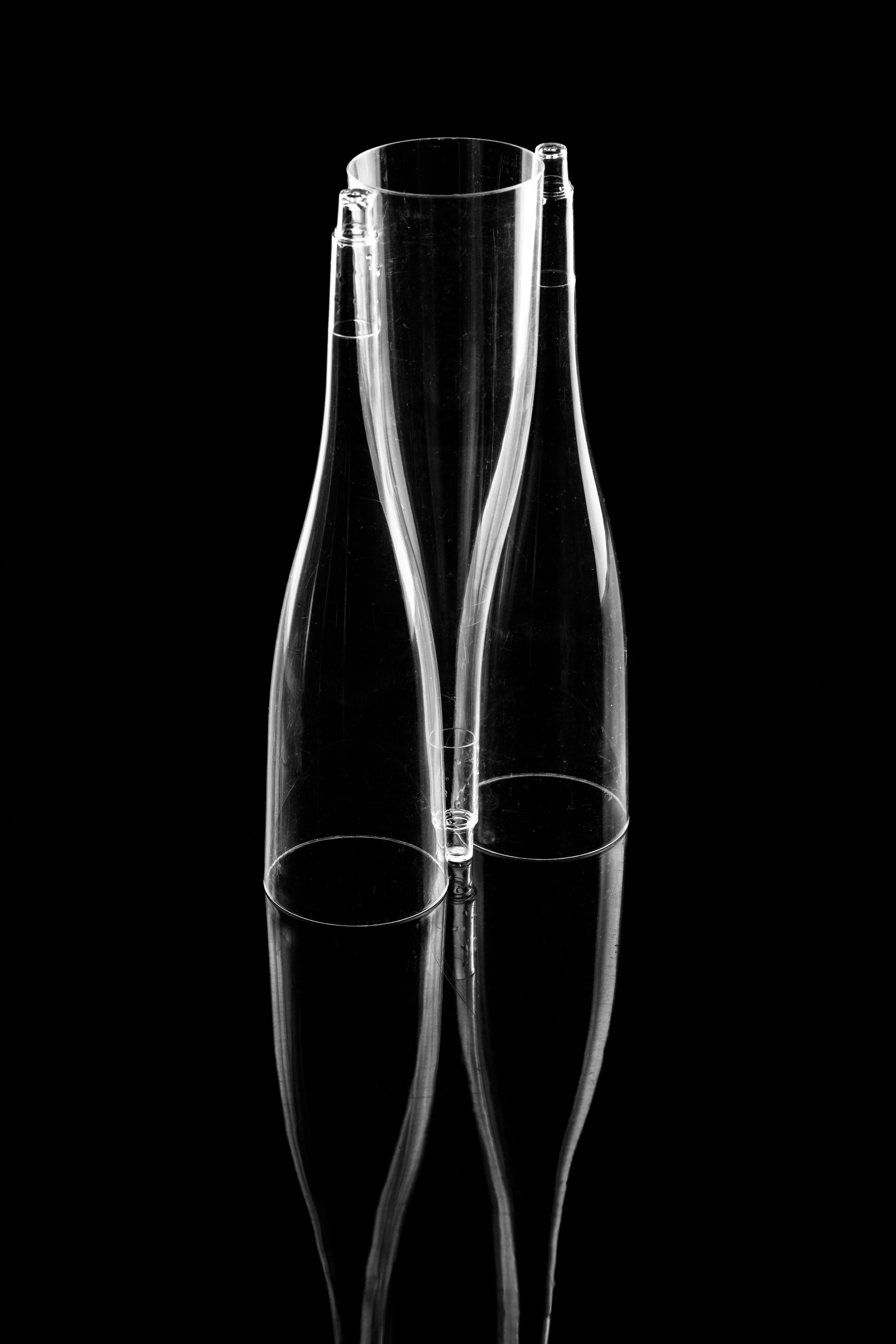 Abstract black and white photo of transparent glass bottles with reflections.
