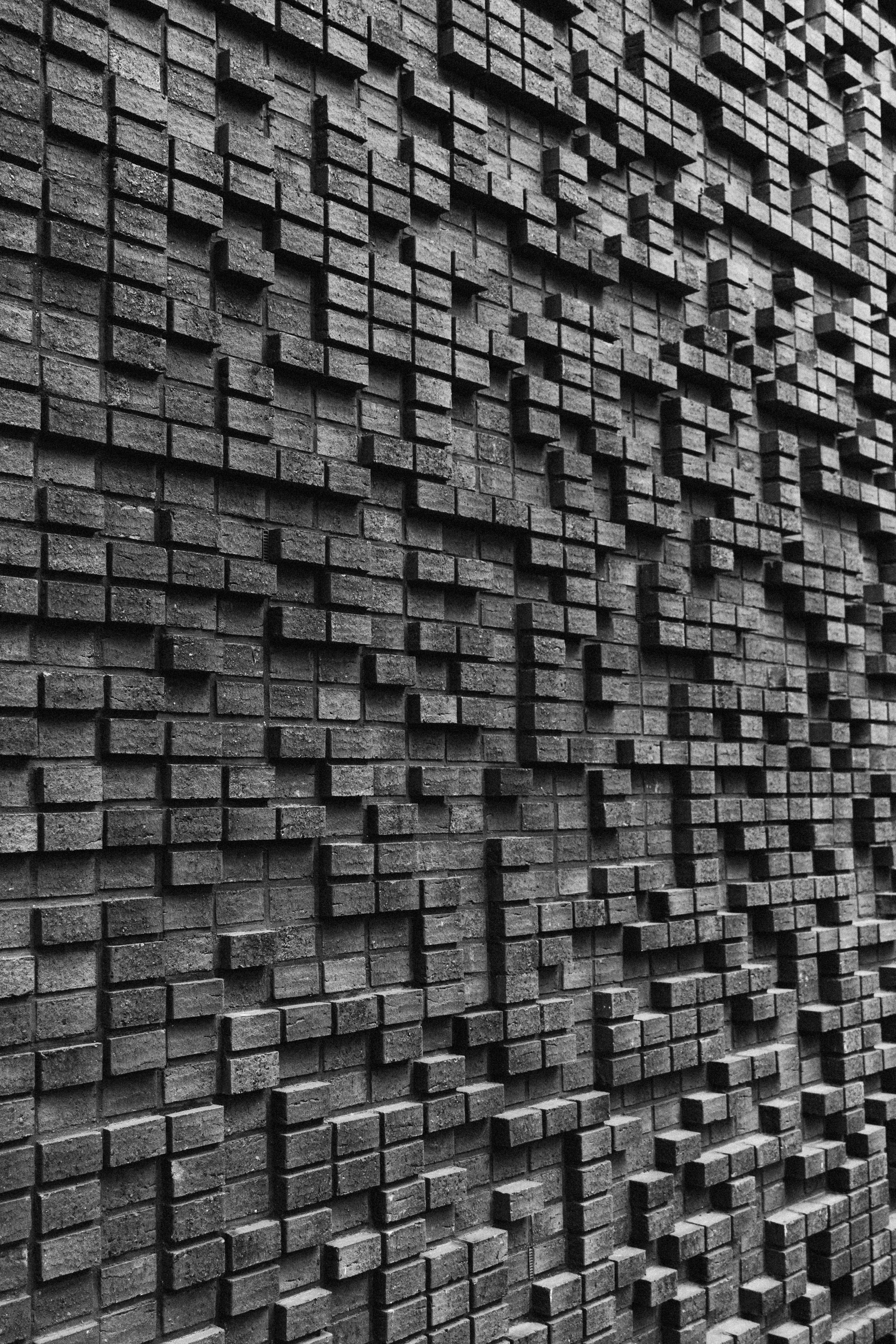 Detailed abstract brick wall with geometric patterns creating a 3D texture.