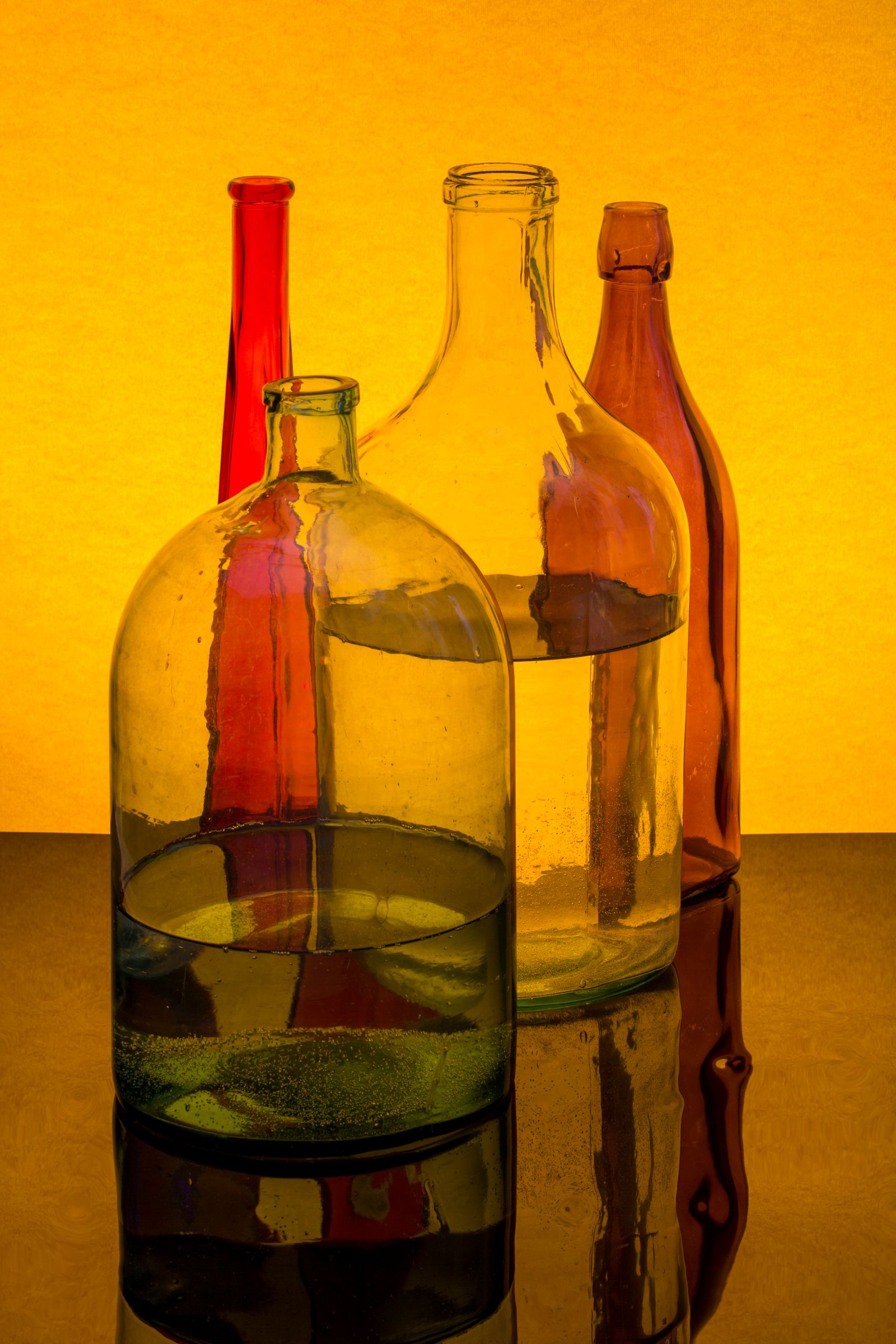 Glass bottles on a gold ground, photo by Valentin Ivantsov on Pexels