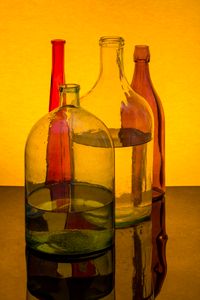 Glass bottles on a gold ground, photo by Valentin Ivantsov on Pexels