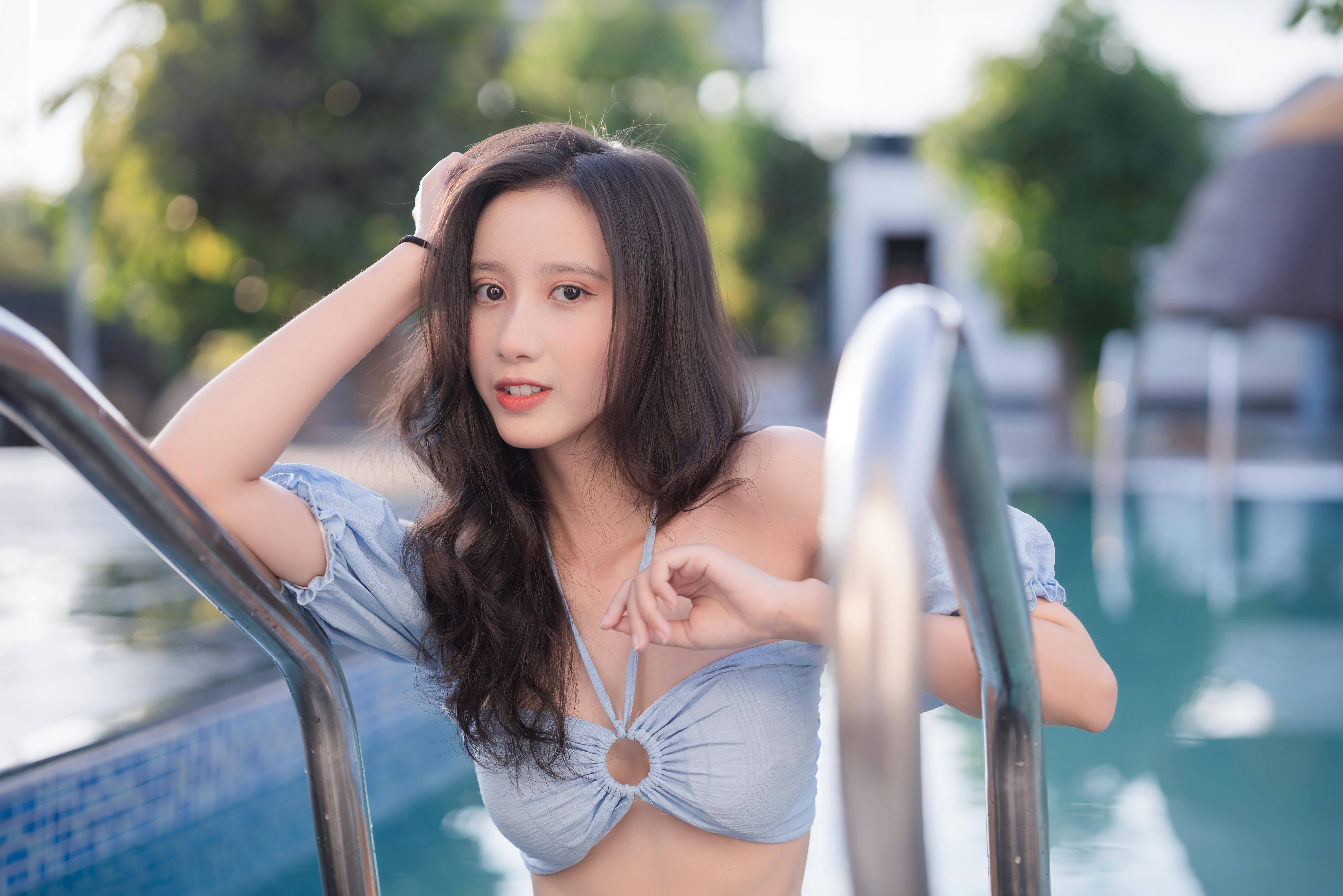 Free A young woman enjoys a sunny day at the pool, showcasing summer vibes. Stock Photo