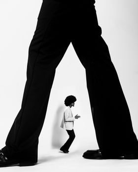 Artistic black and white photo showcasing contrast in scale and fashion.