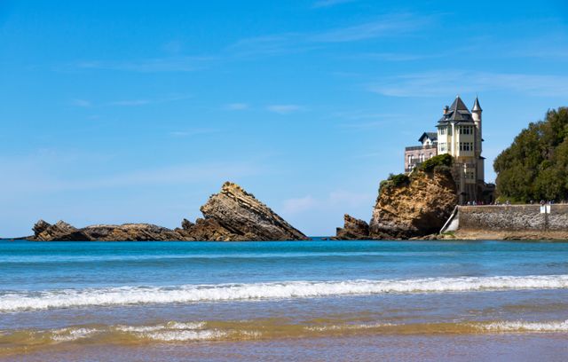 Stunning coastal architecture in Biarritz, France with a rocky seascape under a clear blue sky.