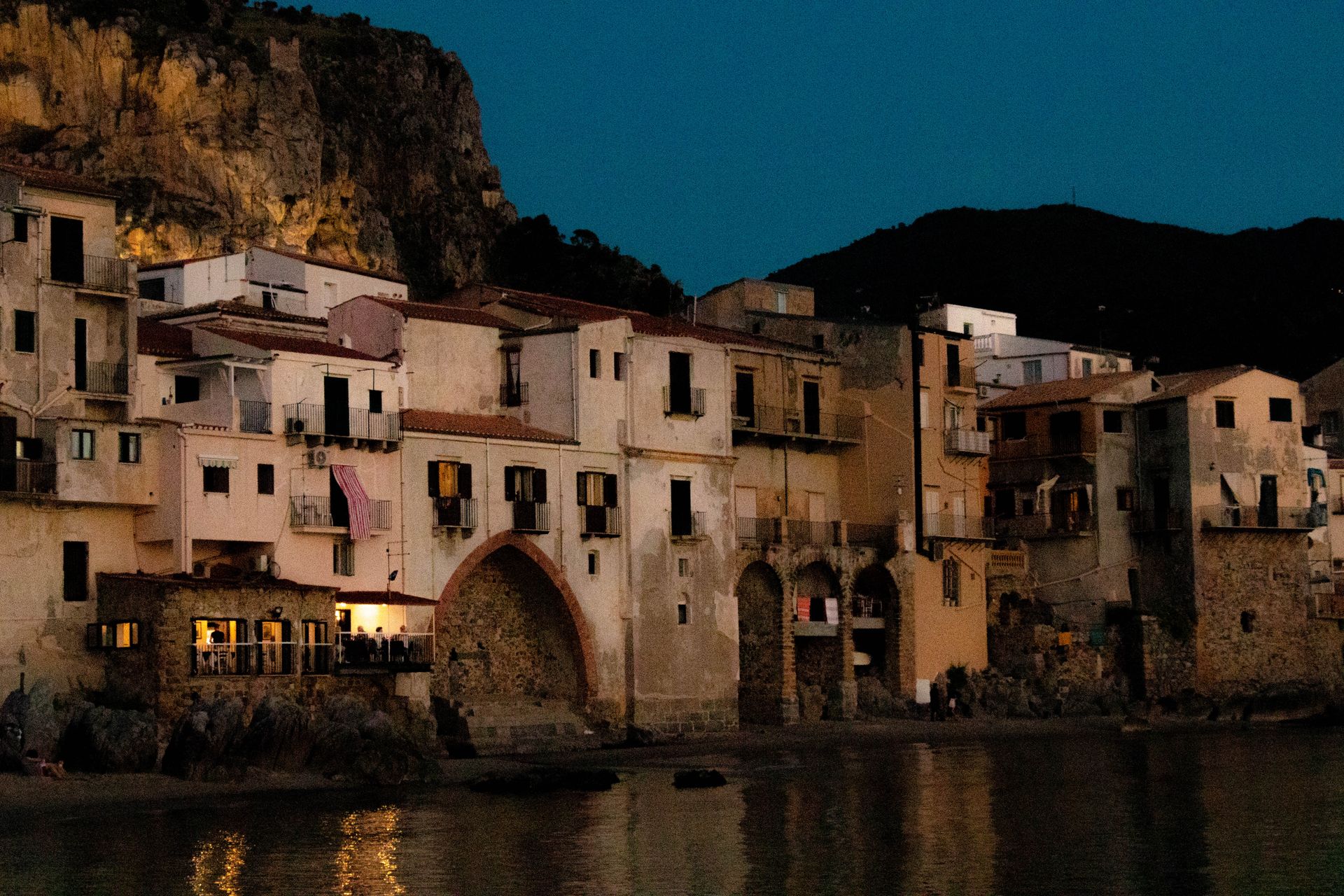 Idyllic Italian seaside village at dusk with historical architecture and tranquil atmosphere.