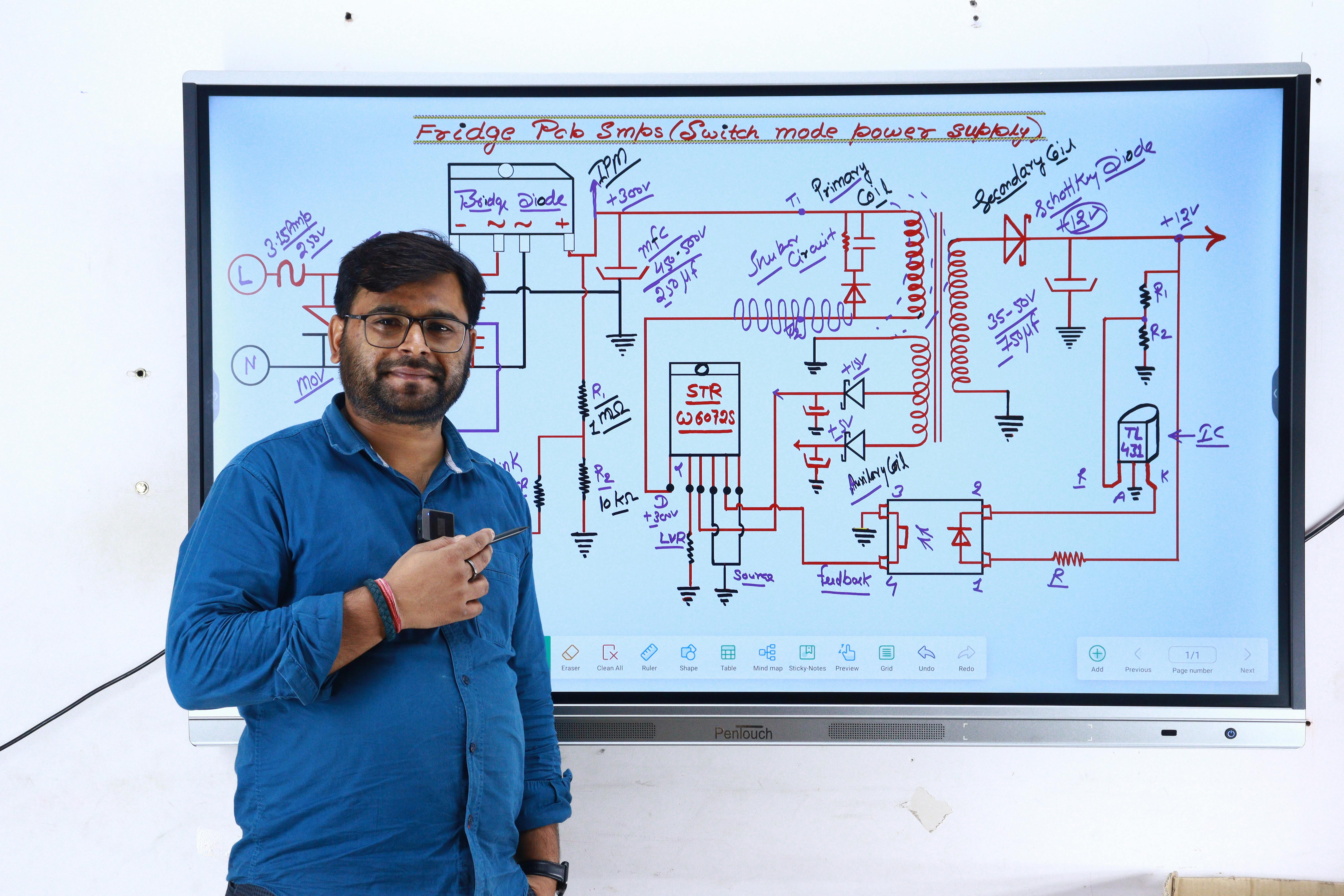 Free Instructor in New Delhi teaching electronics with a circuit diagram on screen. Stock Photo