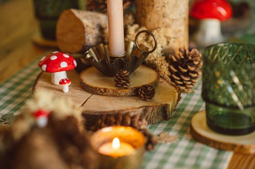 Free Charming woodland-themed table setting with pumpkins, pine cones, and candles perfect for autumn decor. Stock Photo