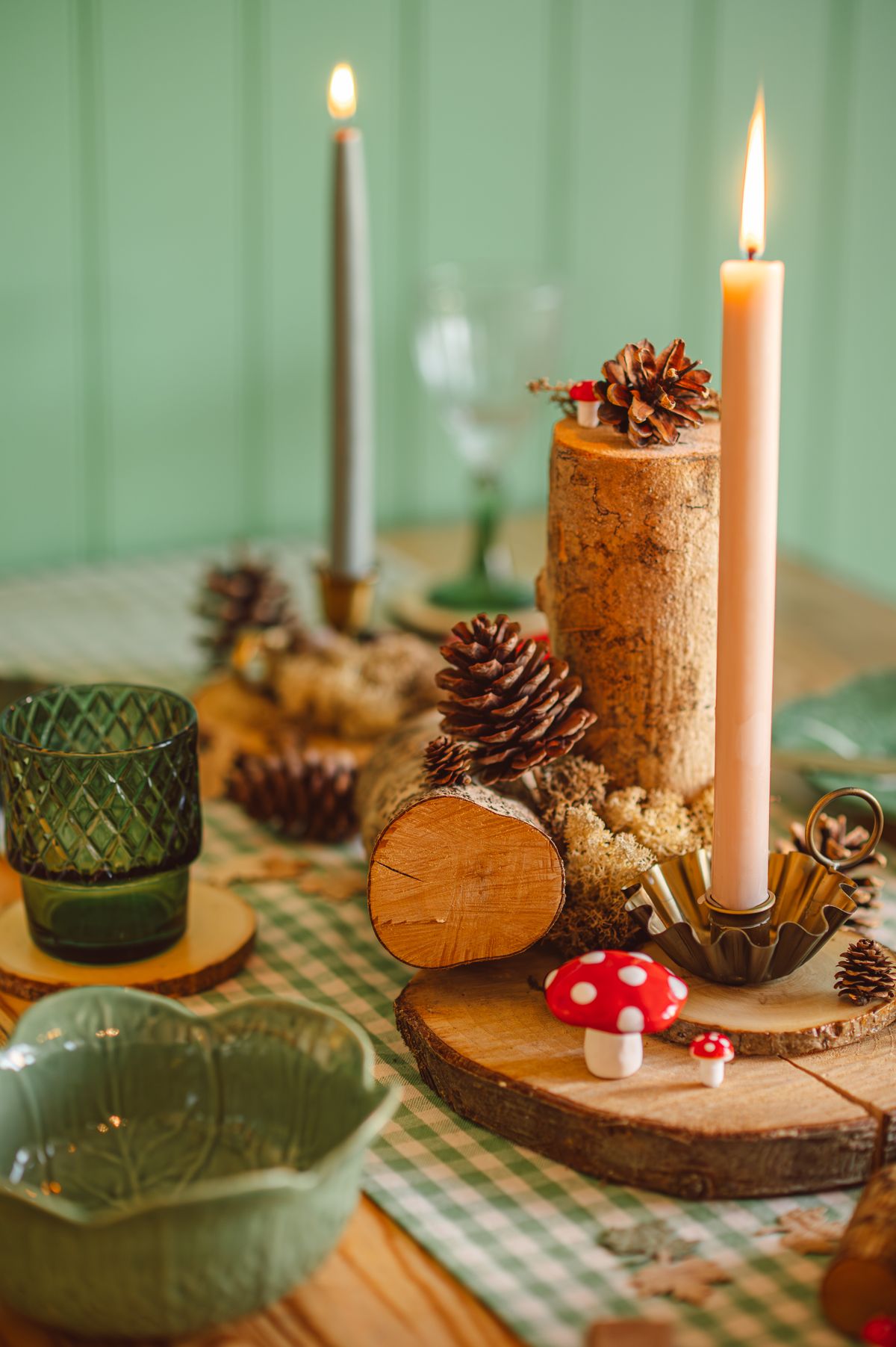 Cozy autumn decor with pinecones, candles, and moss for a warm, rustic table setting. Stock Photo.