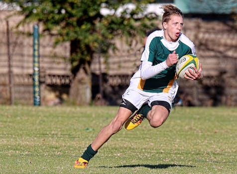 Energetic rugby player running with the ball during a match on a sunny day.