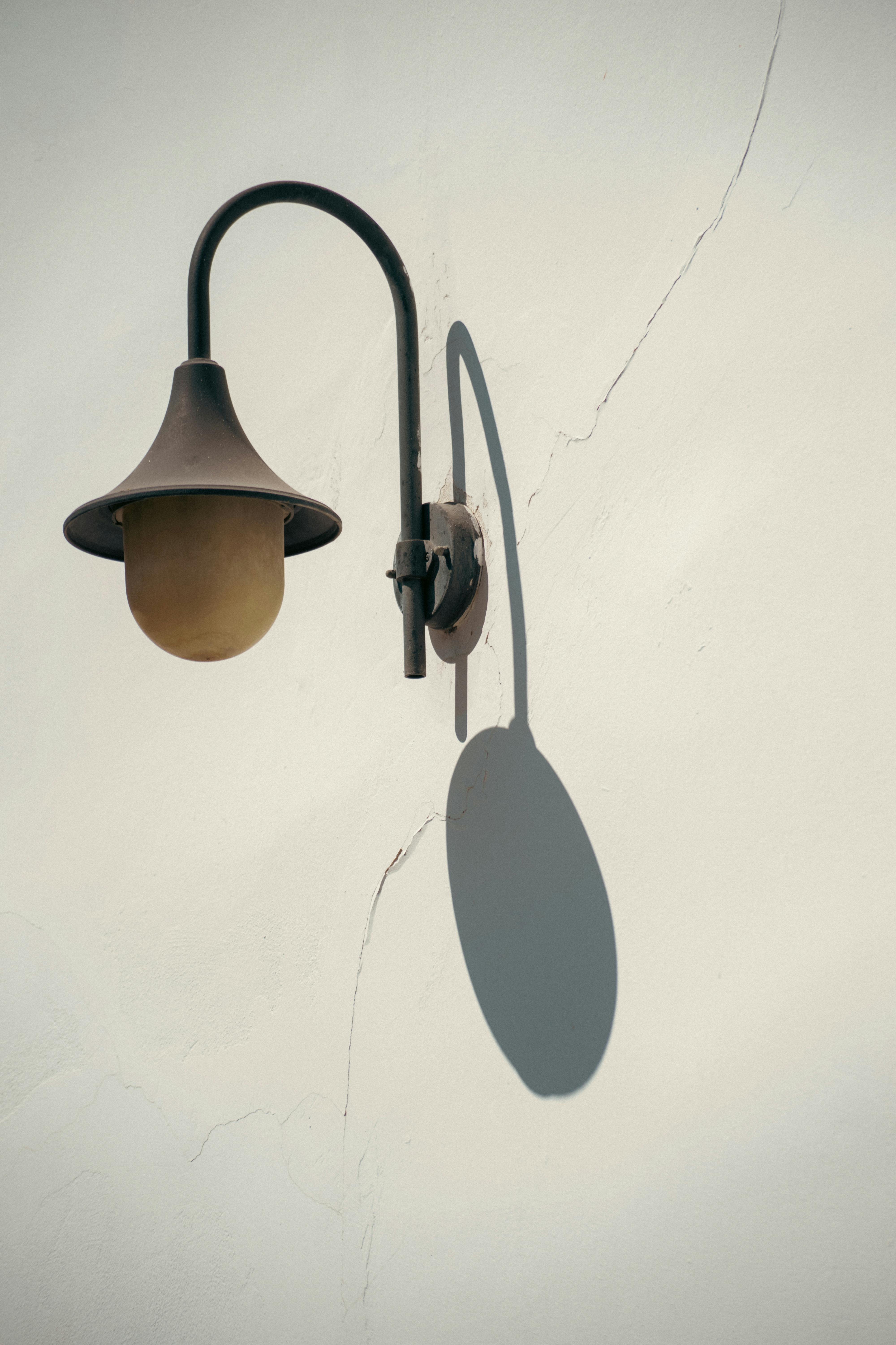 Gratis Lampada artistica da esterno che proietta un'ombra distinta su una parete strutturata. Foto a disposizione