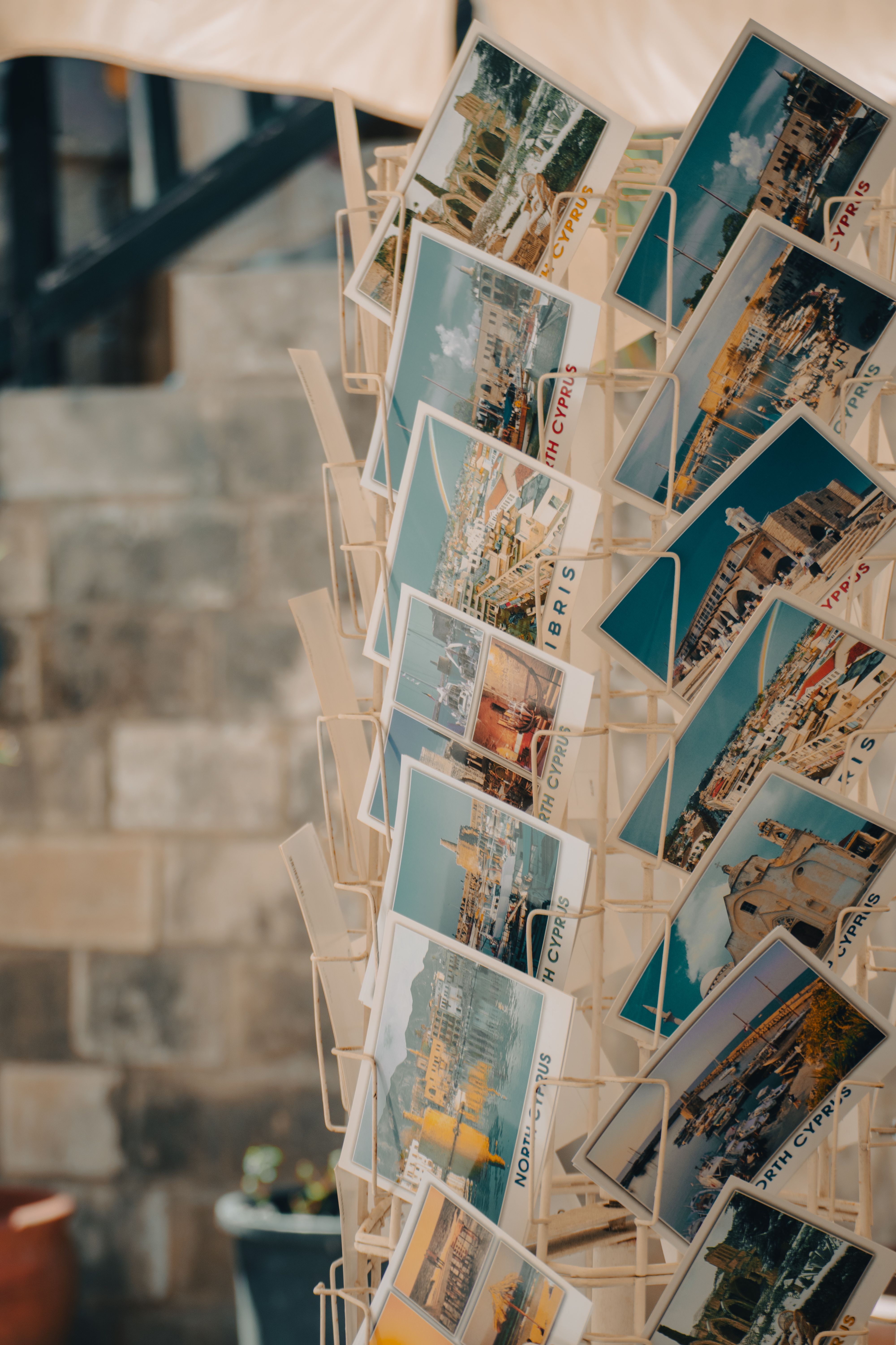 Vibrant collection of seaside postcards displayed on a rack showcasing coastal landscapes.