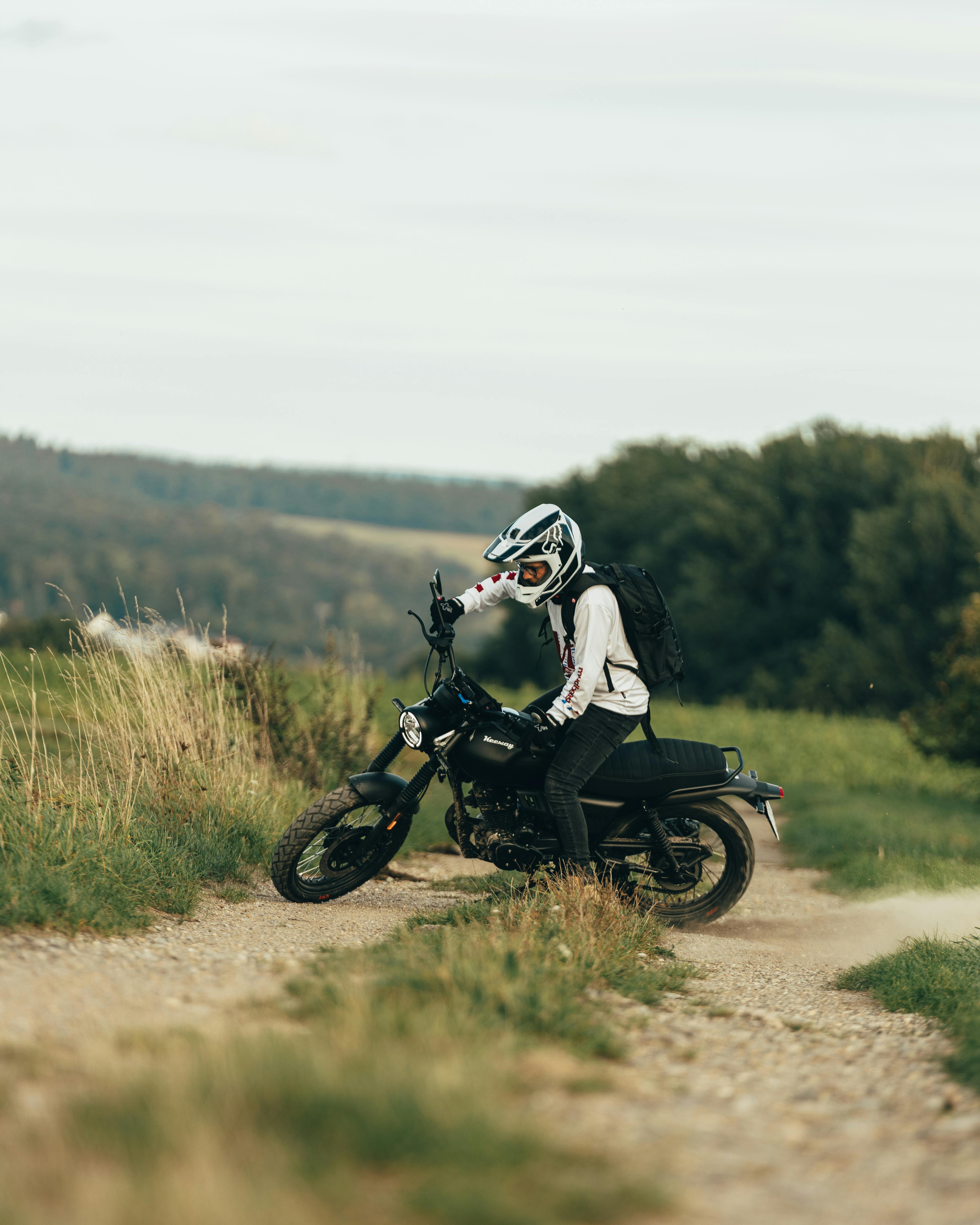 Rider on dirt bike navigating a picturesque off-road path surrounded by nature.