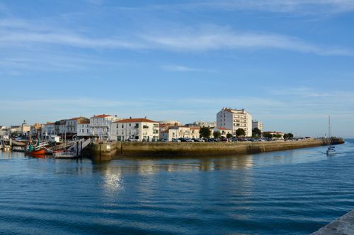 Free Beautiful harbor scene in Les Sables-d'Olonne, France with calm waters and buildings. Stock Photo