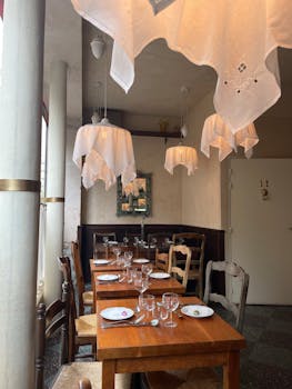 Cozy rustic restaurant interior decorated with elegant hanging lamps and wooden furniture.