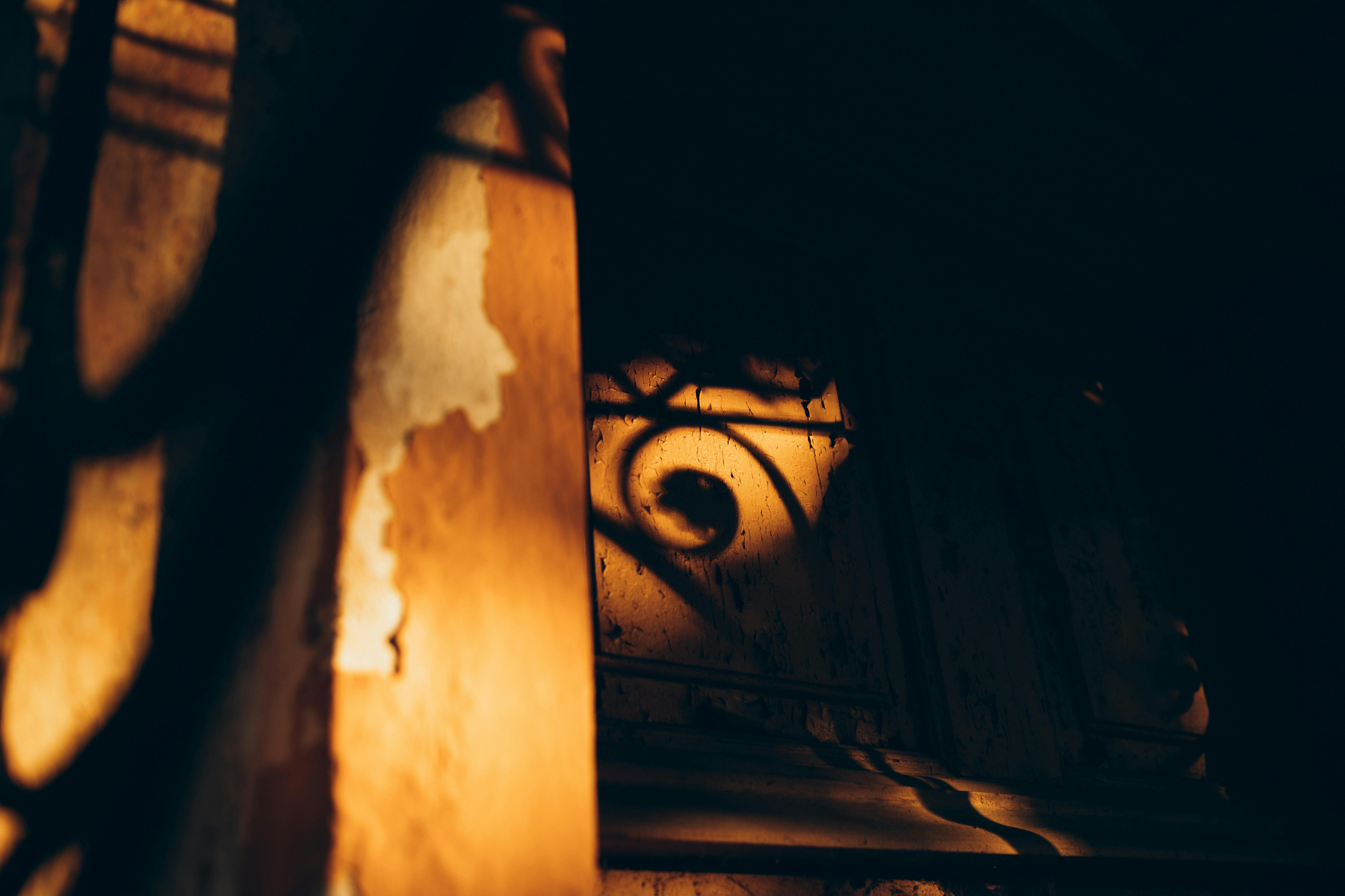 ฟรี การเล่นเงาอันอบอุ่นและเป็นศิลปะบนพื้นผิวไม้เก่าในแสงน้อยสร้างบรรยากาศลึกลับ คลังภาพถ่าย