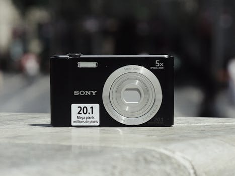 Close-up of a compact digital camera with urban backdrop. Ideal for technology and photography themes.