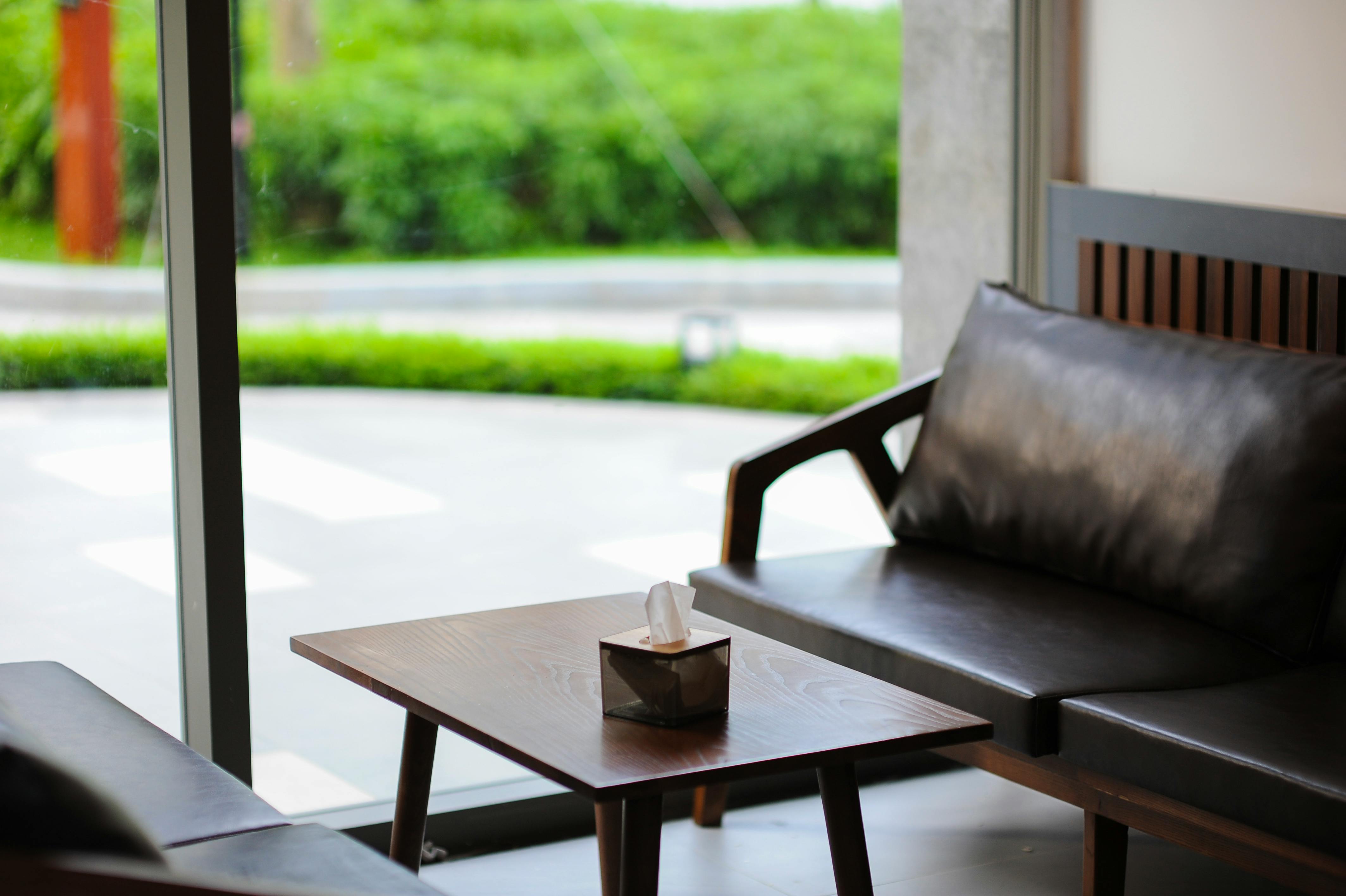 Miễn phí Nội thất trang nhã của khu vực phòng khách hiện đại với ghế sofa da và bàn cà phê gần cửa sổ lớn. Ảnh lưu trữ