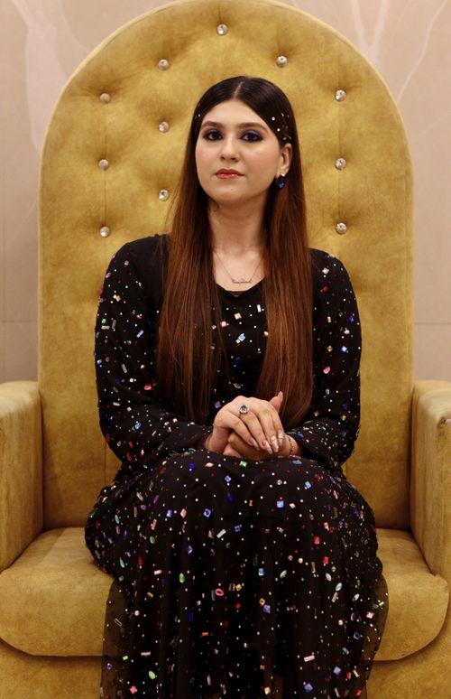 Free Stylish woman seated in a luxurious chair wearing a sequined dress, exuding elegance and poise. Stock Photo