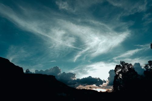 Free Captivating aerial view of clouds over Guanajuato, Mexico at dusk with silhouettes of trees and hills. Stock Photo