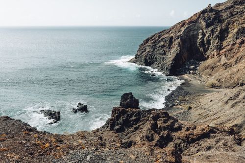 Free Stunning coastal landscape of Alojera beach in Canary Islands, showcasing rugged cliffs and Atlantic Ocean waves. Stock Photo