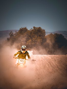Exciting motocross action with a rider kicking up dust on a challenging dirt track in Setif, Algeria.