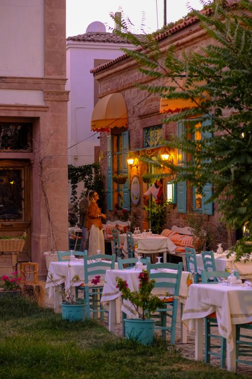 Free A cozy outdoor café with colorful chairs and tables in Balıkesir, captured at twilight. Stock Photo
