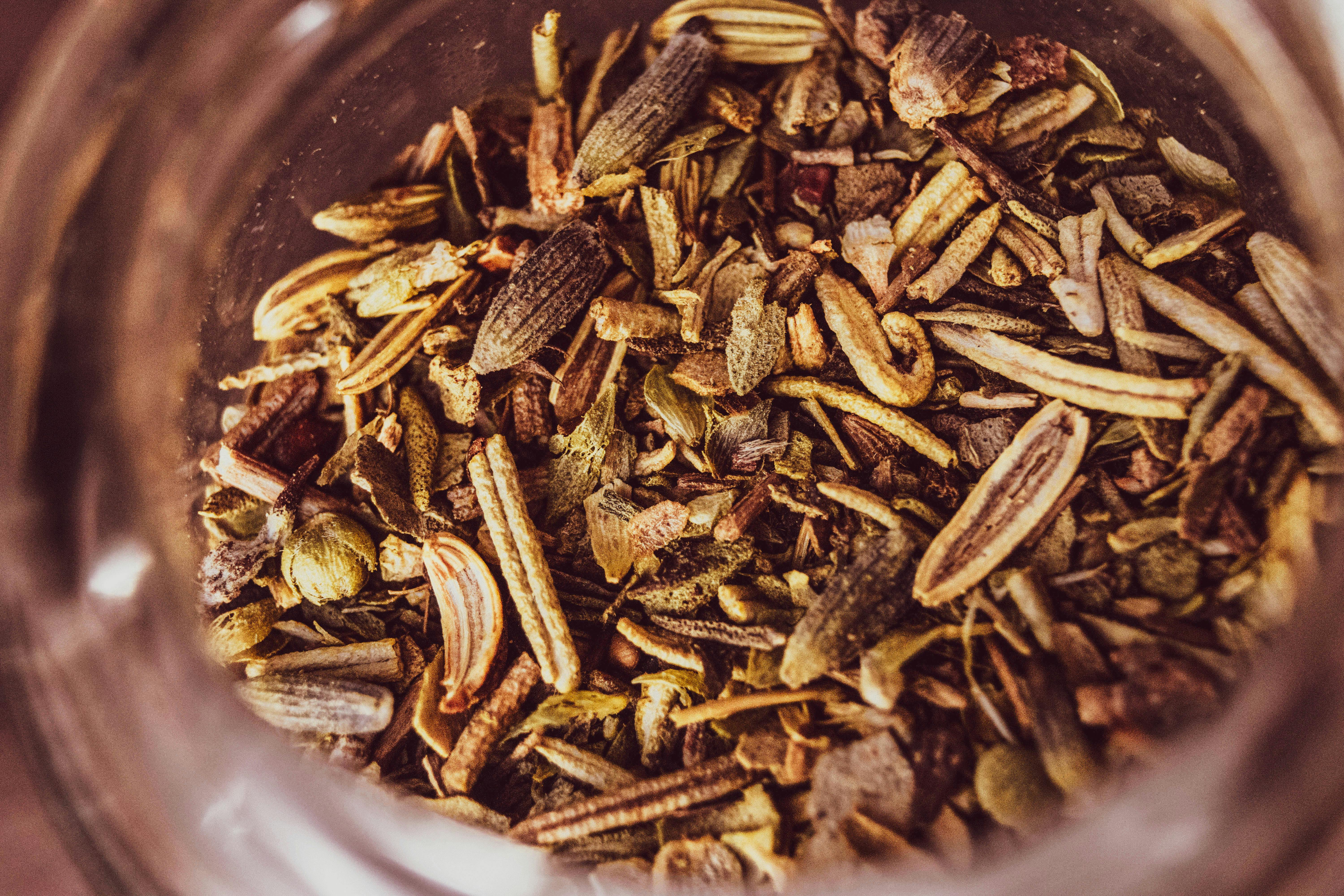 Une photo macro d'un assortiment d'herbes et d'épices séchées dans un pot, mettant en valeur la texture et la couleur.