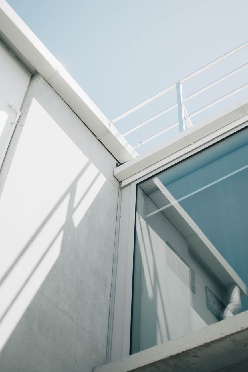 A minimalist architectural design featuring glass and steel elements on a sunny day.