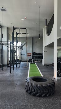Spacious gym filled with modern exercise machines and a green training track.