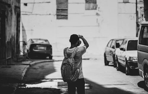 Grayscale Photography of Man Standing Outdoors