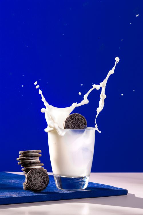 Free Dynamic photo of milk splashing with cookies, creating an eye-catching and vibrant scene. Stock Photo