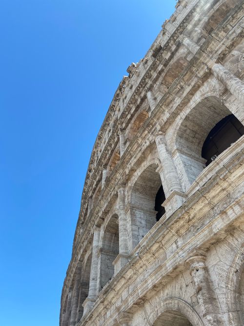 Free Close-up view of the Colosseum in Rome with a clear blue sky, showcasing its ancient architecture. Stock Photo