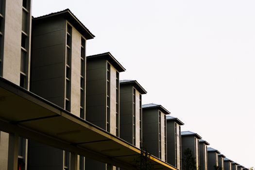 Symmetrical row of modern residential buildings with a minimalist design captured from a low angle.
