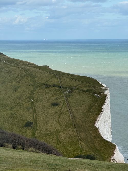 Free Beautiful white cliffs overlooking a vibrant ocean under a clear sky. Stock Photo