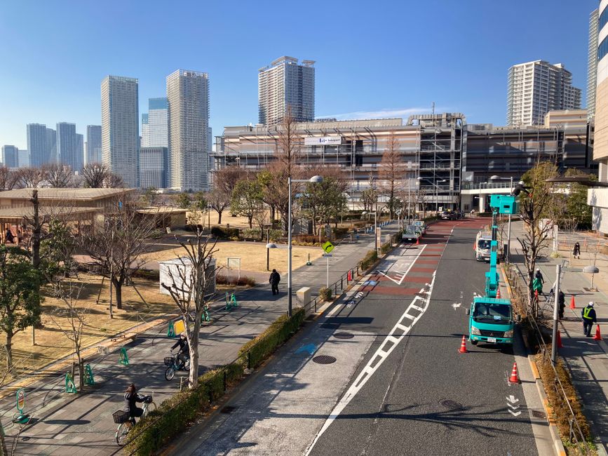 晴れた日に歩行者とトラックが行き交う東京の都会のスカイラインの眺め。