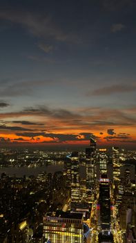 A breathtaking aerial view of New York City at twilight showcasing the skyline against a vibrant sunset.
