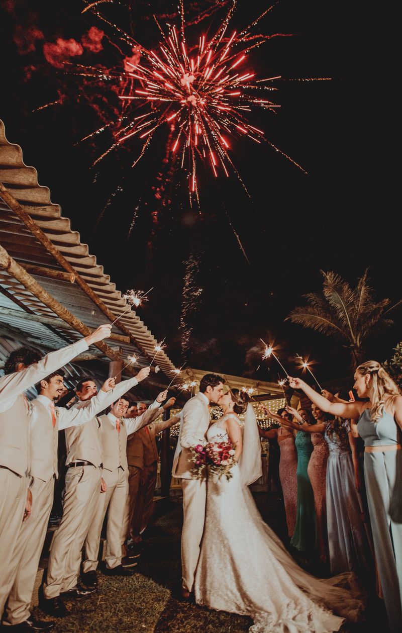 Feu d'artifice au-dessus d'un couple de mariés entouré de cierges magiques