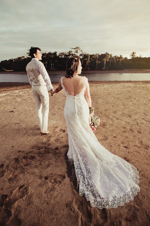 Groom and Bride Standing Near Body of Water